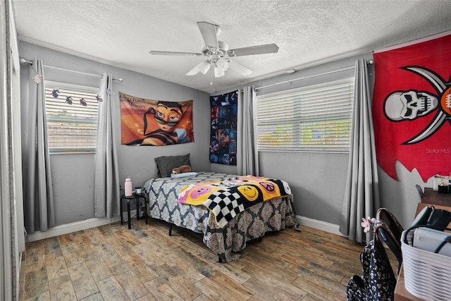 7304 Lakeside Blvd, Tampa, FL 33614 - bedroom with multiple windows, wood finished floors, a textured ceiling, and baseboards