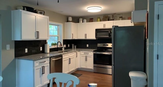 7152 Sandy Ln, Wesley Chapel, FL 33544 - kitchen featuring appliances with stainless steel finishes, a sink, backsplash, light stone counters, and white cabinets
