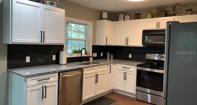 7152 Sandy Ln, Wesley Chapel, FL 33544 - kitchen with stainless steel appliances, a sink, tasteful backsplash, and white cabinets