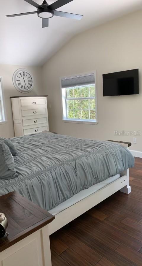 7152 Sandy Ln, Wesley Chapel, FL 33544 - bedroom featuring lofted ceiling, dark wood-style flooring, and a ceiling fan