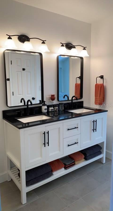 7152 Sandy Ln, Wesley Chapel, FL 33544 - bathroom with double vanity, tile patterned flooring, and baseboards