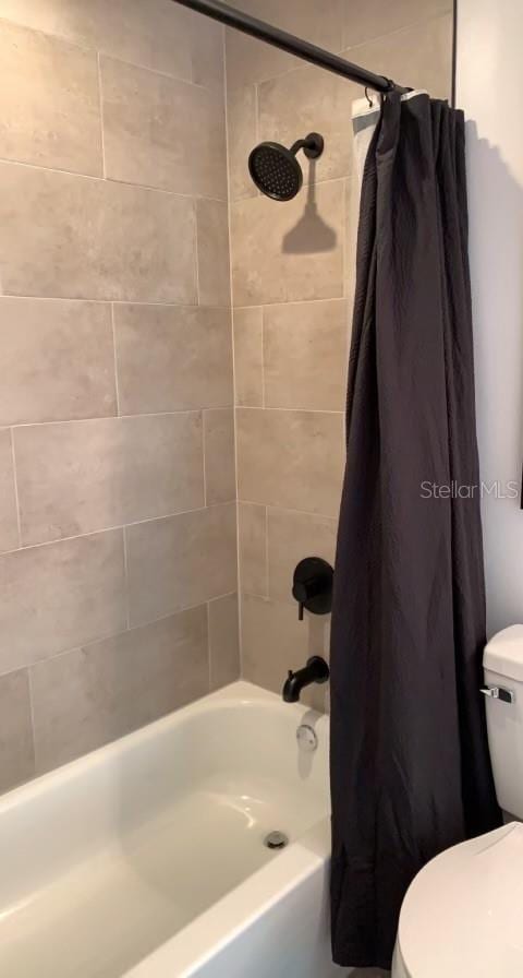 7152 Sandy Ln, Wesley Chapel, FL 33544 - bathroom with toilet and shower / bathtub combination with curtain