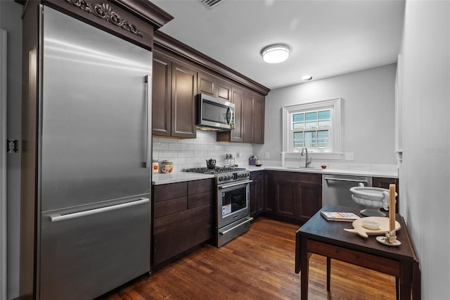 475 28th Ave N, Saint Petersburg, FL 33704 - kitchen featuring premium appliances, dark brown cabinetry, dark wood finished floors, and light countertops
