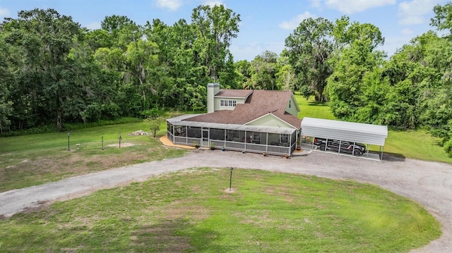 1611 County Road 753s, Webster, FL 33597 - view of front of home featuring dirt driveway, a detached carport, a front yard, a chimney, and a sunroom