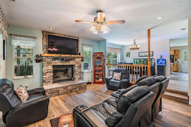 1611 County Road 753s, Webster, FL 33597 - living area with a textured ceiling, a fireplace, ceiling fan, hardwood / wood-style flooring, and a chandelier