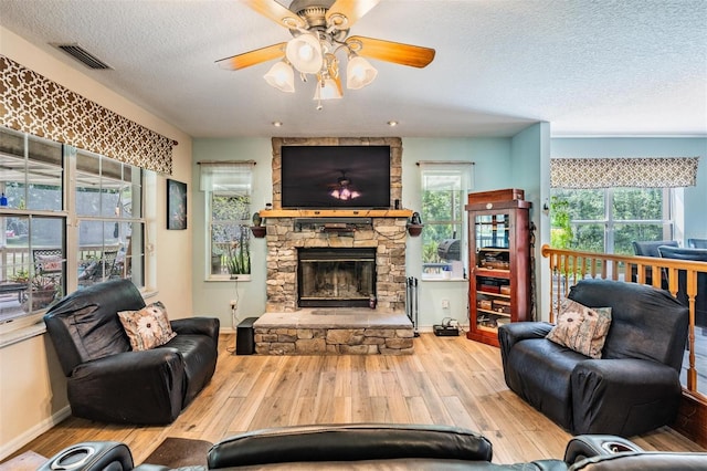 1611 County Road 753s, Webster, FL 33597 - living room with wood finished floors, a fireplace, a textured ceiling, ceiling fan, and baseboards