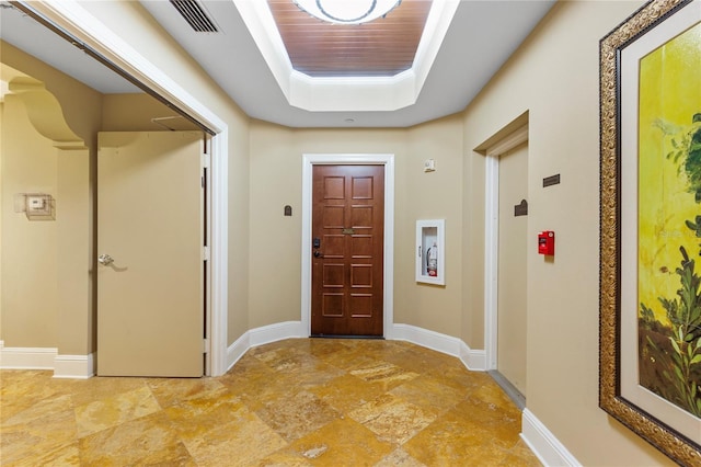 521 Mandalay Ave Unit 307, Clearwater Beach, FL 33767 - entrance foyer with a tray ceiling, light stone finish floors, and baseboards