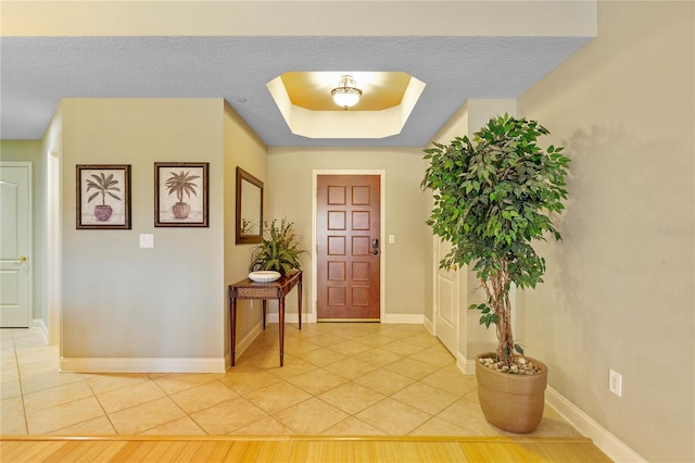 521 Mandalay Ave Unit 307, Clearwater Beach, FL 33767 - foyer featuring light tile patterned floors, baseboards, and a tray ceiling