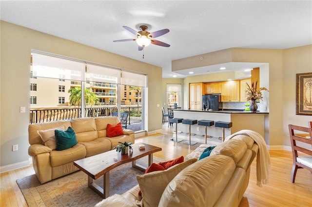 521 Mandalay Ave Unit 307, Clearwater Beach, FL 33767 - living room featuring a ceiling fan, baseboards, and light wood finished floors