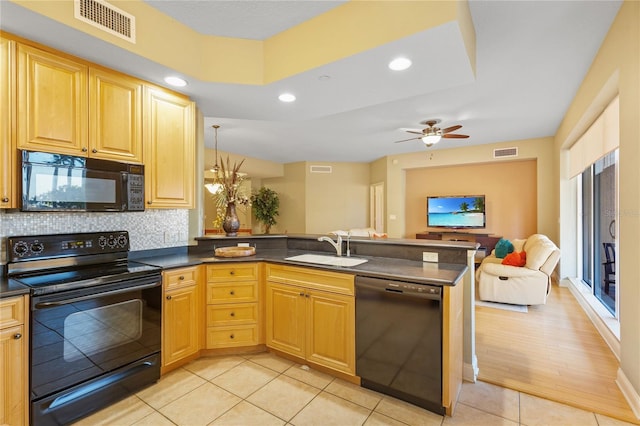 521 Mandalay Ave Unit 307, Clearwater Beach, FL 33767 - kitchen featuring black appliances, a sink, a peninsula, dark countertops, and light tile patterned floors