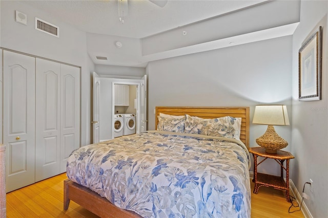 521 Mandalay Ave Unit 307, Clearwater Beach, FL 33767 - bedroom with light wood-style floors, washing machine and clothes dryer, a closet, baseboards, and a ceiling fan