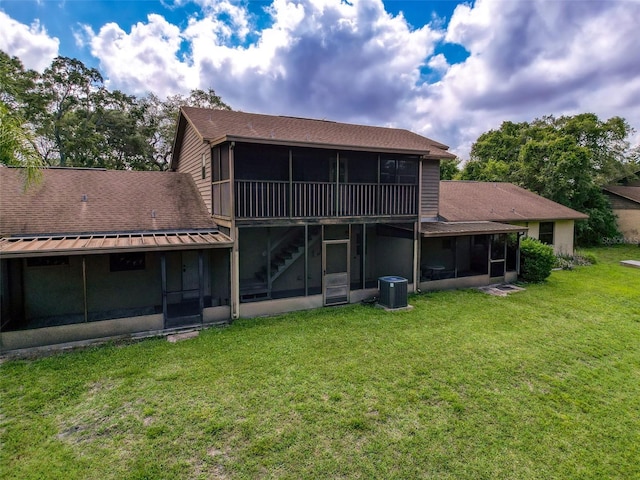 507 E Curlew Pl, Tarpon Springs, FL 34689 - rear view of house featuring a sunroom, a yard, roof with shingles, central AC unit, and stairs