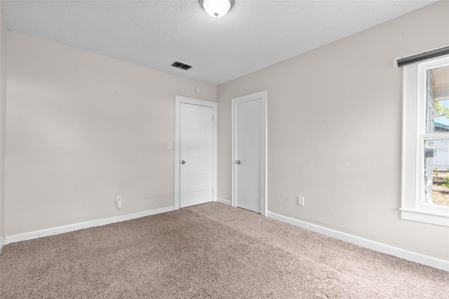 6489 30th St N, Saint Petersburg, FL 33702 - unfurnished room with carpet floors, baseboards, healthy amount of natural light, and a textured ceiling