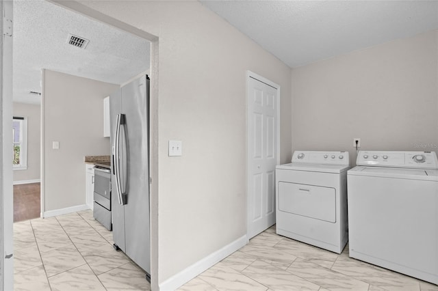 6489 30th St N, Saint Petersburg, FL 33702 - washroom with light marble finish flooring, independent washer and dryer, a textured ceiling, and baseboards