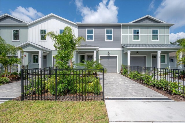 5530 N 9th St Unit 6, Tampa, FL 33604 - view of front of home featuring an attached garage, decorative driveway, stucco siding, a standing seam roof, and metal roof