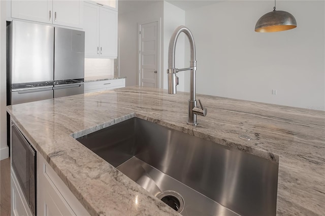 5530 N 9th St Unit 6, Tampa, FL 33604 - kitchen featuring a sink, white cabinetry, built in microwave, light stone counters, and pendant lighting