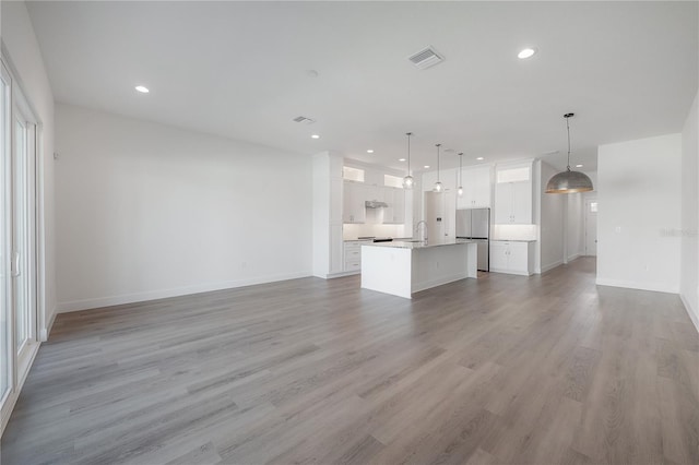 5530 N 9th St Unit 6, Tampa, FL 33604 - unfurnished living room with recessed lighting, light wood-type flooring, baseboards, and a sink