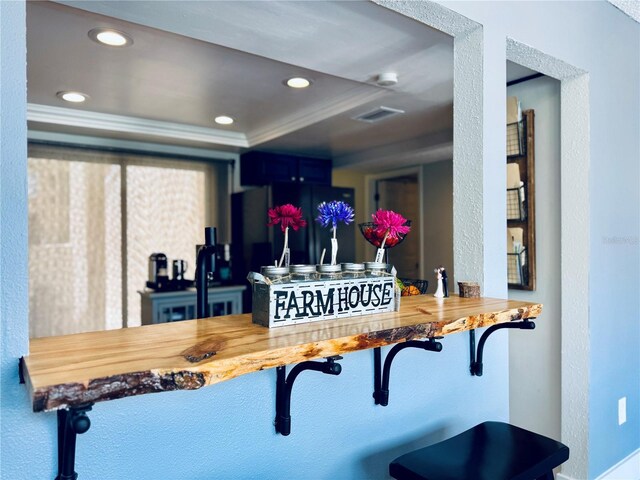 4360 Outrigger Ln, Tampa, FL 33615 - detailed view of black refrigerator, a raised ceiling, ornamental molding, and recessed lighting