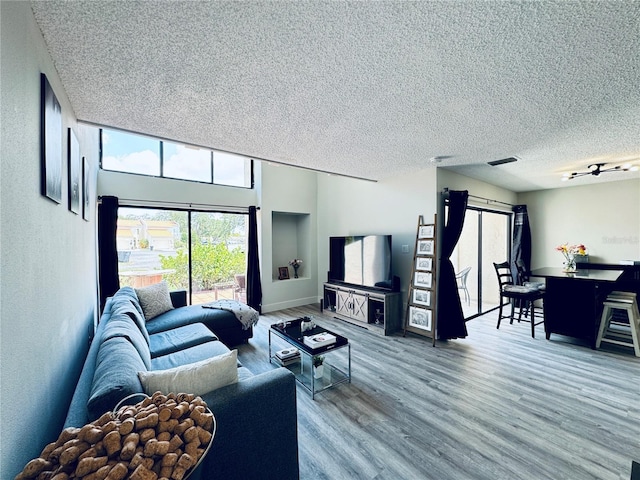 4360 Outrigger Ln, Tampa, FL 33615 - living room featuring a textured ceiling, wood finished floors, and baseboards