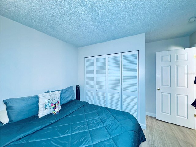 4360 Outrigger Ln, Tampa, FL 33615 - bedroom with wood finished floors, a closet, a textured ceiling, and baseboards
