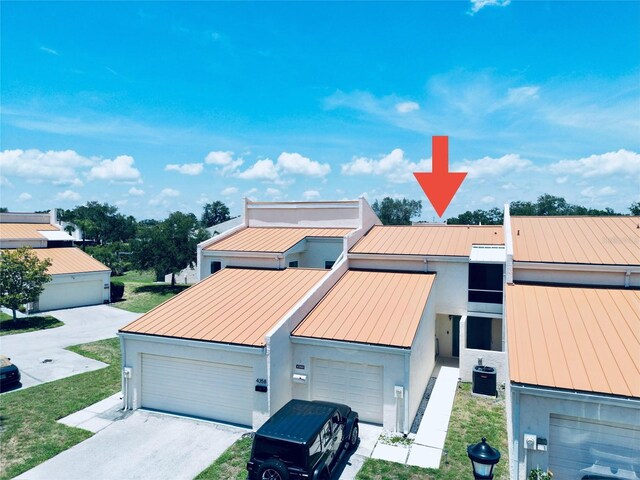 4360 Outrigger Ln, Tampa, FL 33615 - view of front of house featuring a standing seam roof, metal roof, stucco siding, and a garage