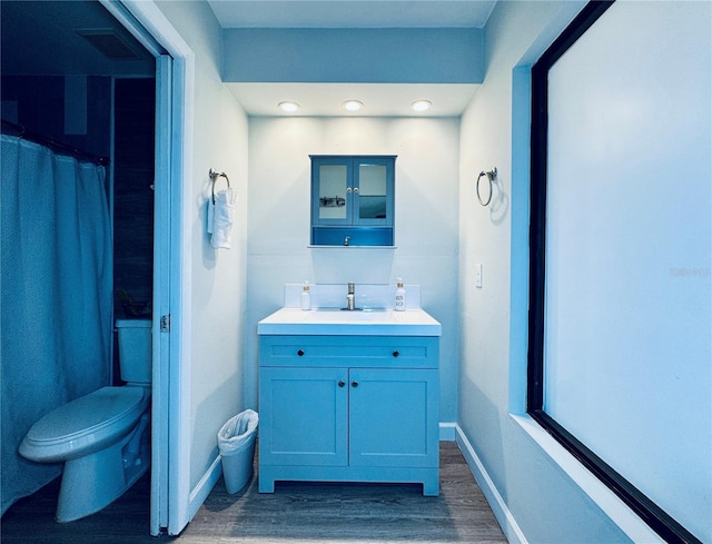 4360 Outrigger Ln, Tampa, FL 33615 - bathroom with wood finished floors, vanity, toilet, baseboards, and recessed lighting