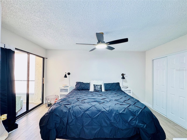 4360 Outrigger Ln, Tampa, FL 33615 - bedroom featuring light wood finished floors, a textured ceiling, a ceiling fan, a closet, and access to exterior