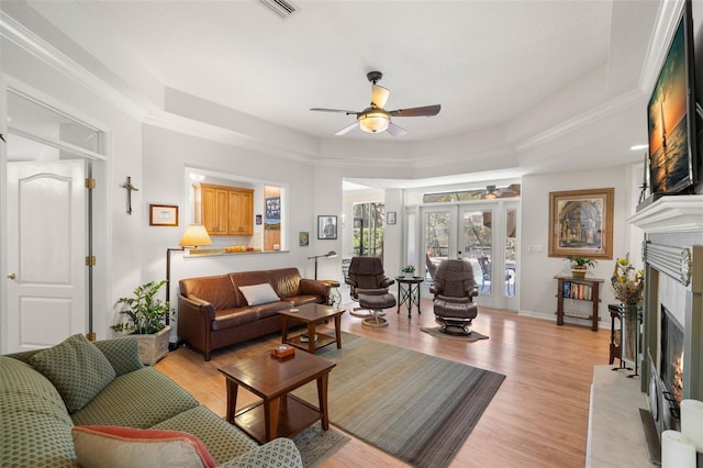 8708 Laurel Dr N, Pinellas Park, FL 33782 - living room featuring ceiling fan, a warm lit fireplace, light wood-style floors, and baseboards