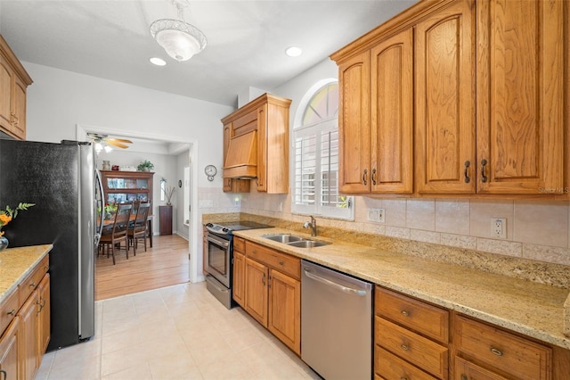 8708 Laurel Dr N, Pinellas Park, FL 33782 - kitchen with appliances with stainless steel finishes, a sink, tasteful backsplash, and brown cabinetry