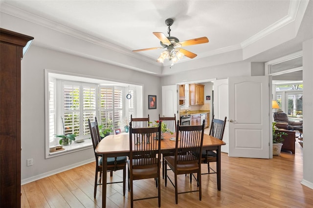 8708 Laurel Dr N, Pinellas Park, FL 33782 - dining area featuring a tray ceiling, light wood-style flooring, ceiling fan, crown molding, and baseboards