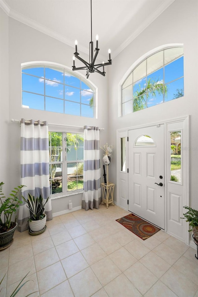 8708 Laurel Dr N, Pinellas Park, FL 33782 - tiled entryway featuring a chandelier, a towering ceiling, plenty of natural light, and crown molding