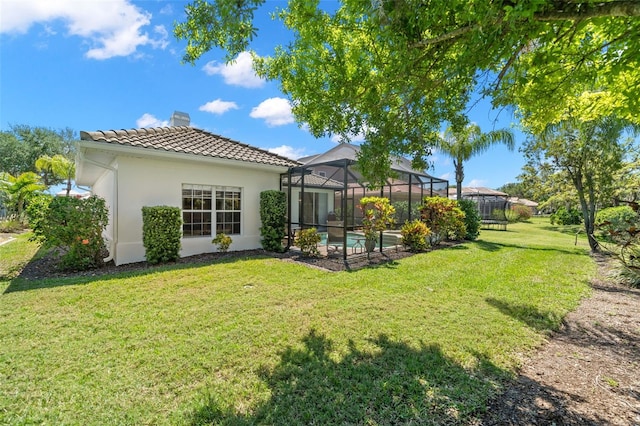 8708 Laurel Dr N, Pinellas Park, FL 33782 - back of house featuring a chimney, a tiled roof, a lawn, stucco siding, and a lanai