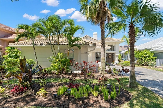 8708 Laurel Dr N, Pinellas Park, FL 33782 - mediterranean / spanish home featuring a tiled roof, a chimney, and central AC