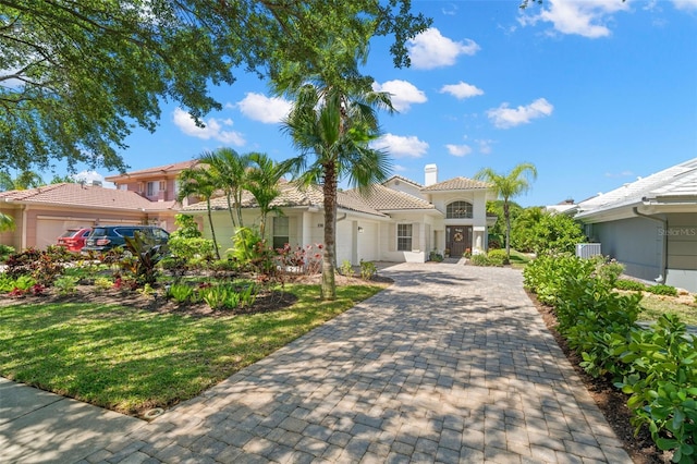 8708 Laurel Dr N, Pinellas Park, FL 33782 - mediterranean / spanish-style house with a garage, decorative driveway, a tile roof, and stucco siding