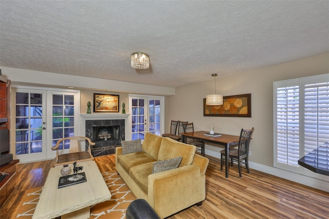 3053 S Concordia Ave Unit A, Tampa, FL 33629 - living room with french doors, wood finished floors, a textured ceiling, a high end fireplace, and baseboards