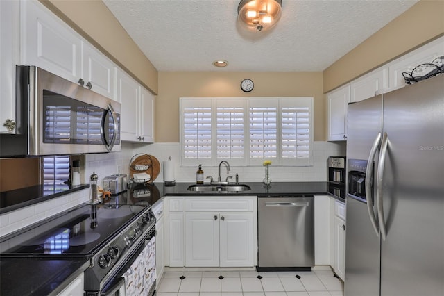 3053 S Concordia Ave Unit A, Tampa, FL 33629 - kitchen with appliances with stainless steel finishes, a sink, white cabinetry, dark countertops, and a textured ceiling