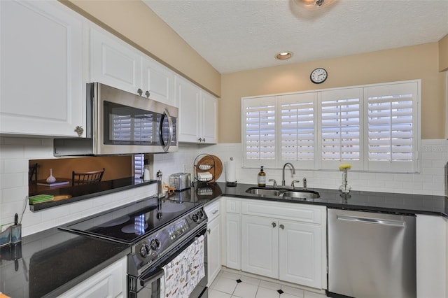 3053 S Concordia Ave Unit A, Tampa, FL 33629 - kitchen featuring stainless steel appliances, a sink, white cabinets, backsplash, and a textured ceiling