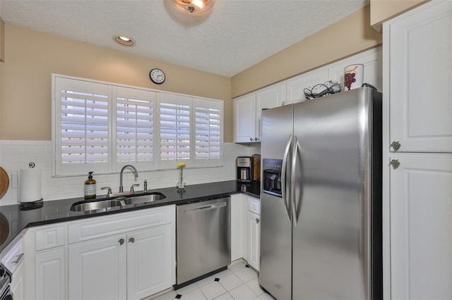 3053 S Concordia Ave Unit A, Tampa, FL 33629 - kitchen with stainless steel appliances, a sink, dark countertops, white cabinets, and a textured ceiling