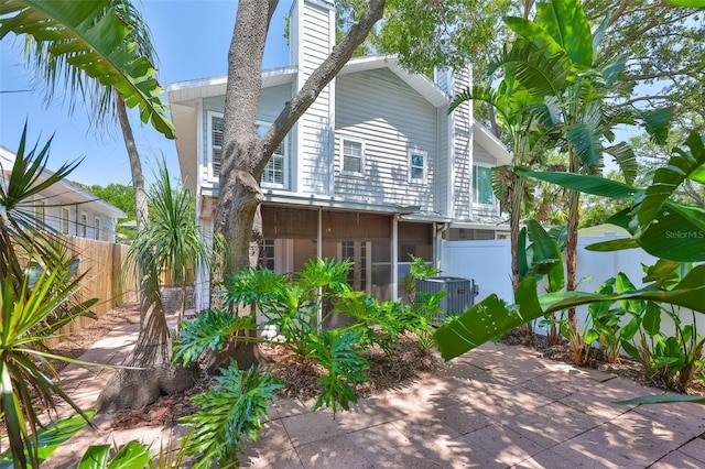 3053 S Concordia Ave Unit A, Tampa, FL 33629 - view of side of property featuring a chimney, a patio, a sunroom, and central air condition unit