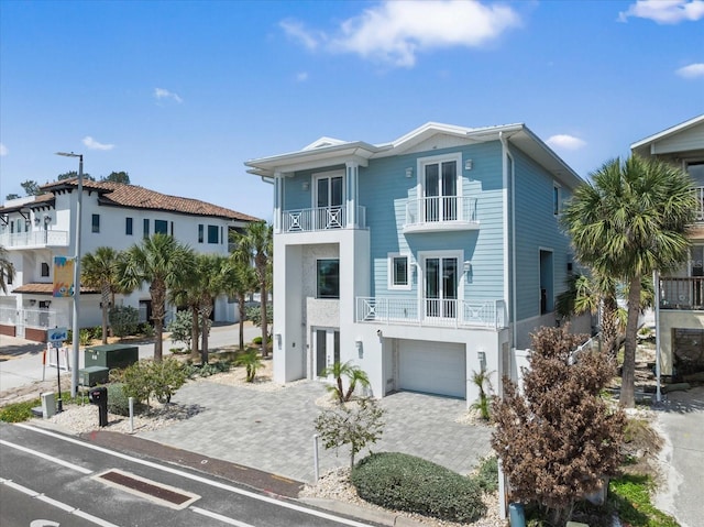 2 Gulf Blvd, Indian Rocks Beach, FL 33785 - view of front of property with a balcony, decorative driveway, an attached garage, and stucco siding