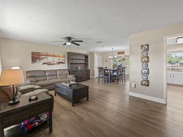 718 Crk 467, Lake Panasoffkee, FL 33538 - living room with a chandelier, a textured ceiling, ceiling fan, wood finished floors, and healthy amount of natural light