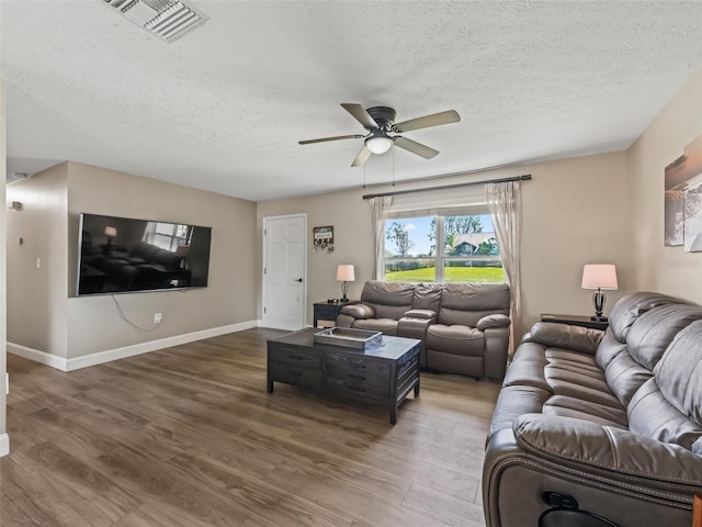 718 Crk 467, Lake Panasoffkee, FL 33538 - living area featuring a textured ceiling, a ceiling fan, wood finished floors, and baseboards