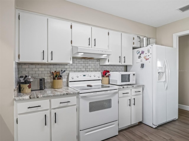 718 Crk 467, Lake Panasoffkee, FL 33538 - kitchen featuring under cabinet range hood, white appliances, light countertops, wood finished floors, and white cabinetry