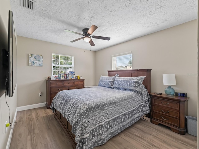 718 Crk 467, Lake Panasoffkee, FL 33538 - bedroom featuring wood finished floors, baseboards, a textured ceiling, and a ceiling fan