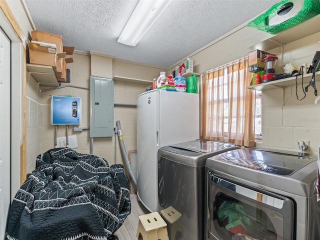 718 Crk 467, Lake Panasoffkee, FL 33538 - laundry room featuring electric panel, separate washer and dryer, a textured ceiling, and concrete block wall