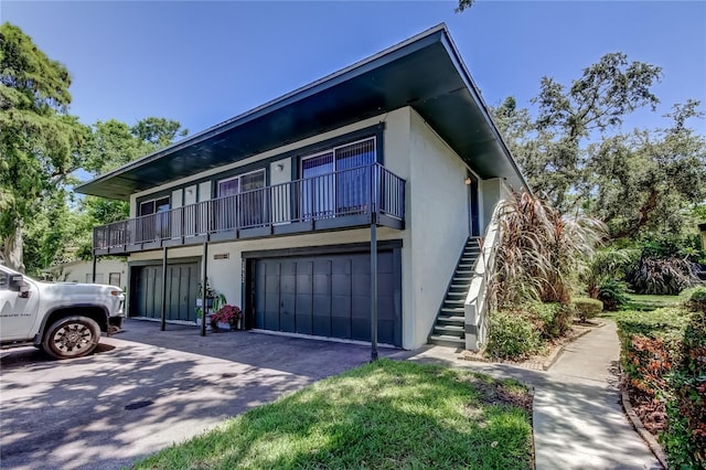 2932 Lichen Ln Unit D, Clearwater, FL 33760 - multi unit property featuring an attached garage, stucco siding, driveway, stairway, and a balcony