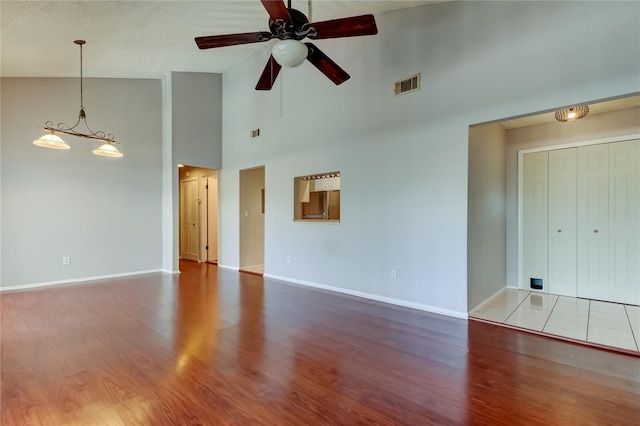 2932 Lichen Ln Unit D, Clearwater, FL 33760 - unfurnished living room with high vaulted ceiling, wood finished floors, baseboards, and ceiling fan