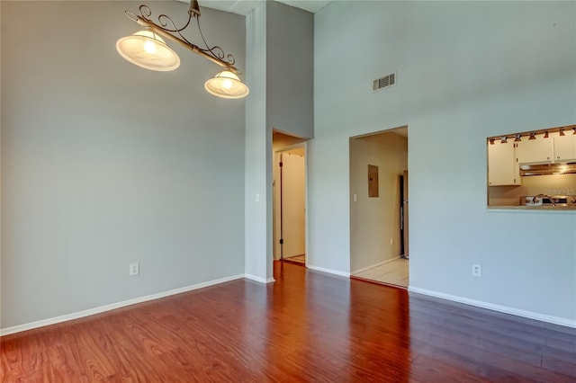 2932 Lichen Ln Unit D, Clearwater, FL 33760 - empty room featuring wood finished floors, a towering ceiling, and baseboards