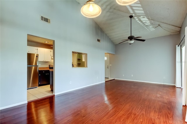 2932 Lichen Ln Unit D, Clearwater, FL 33760 - unfurnished living room featuring high vaulted ceiling, a ceiling fan, light wood-style flooring, and baseboards