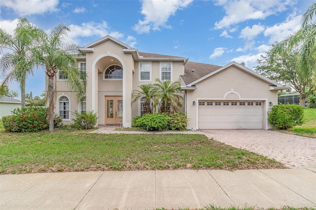 239 Beacon Pointe Dr, Ocoee, FL 34761 - view of front of home featuring french doors, a garage, stucco siding, and a front lawn